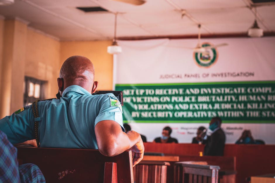 A man in uniform attending a judicial panel meeting indoors.