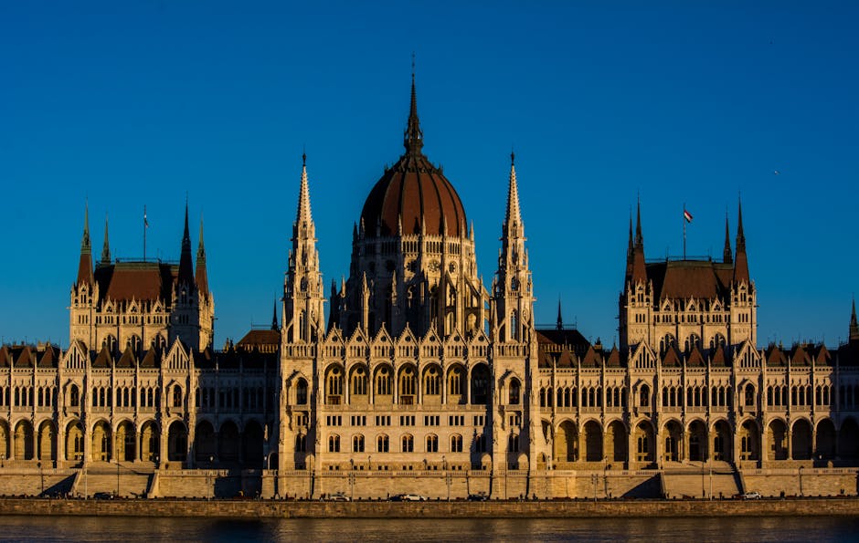 Breathtaking view of the Hungarian Parliament Building bathed in warm sunset light, showcasing its Gothic Revival architecture.