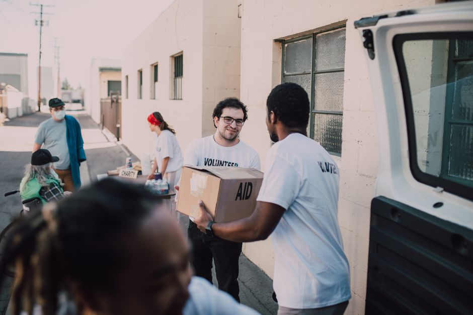 Group of volunteers handing out aid boxes to support community donations.