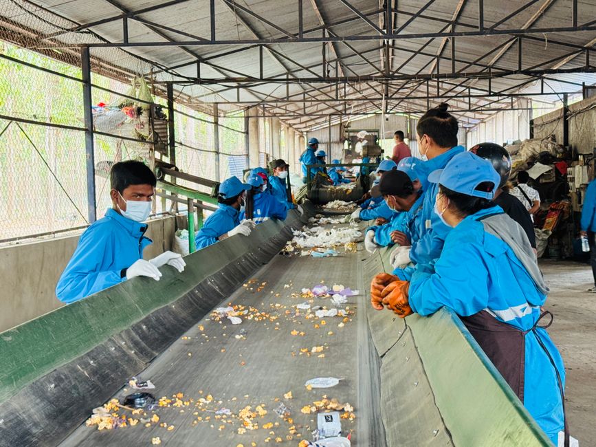 Cardboard parcels moving along a conveyor belt inside a large sorting facility