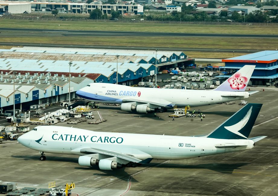 Ground crew loading freight containers into the cargo hold of an airplane