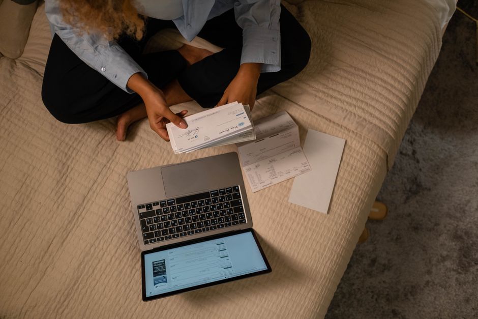 Hands typing a card number into a laptop to pay a bill online