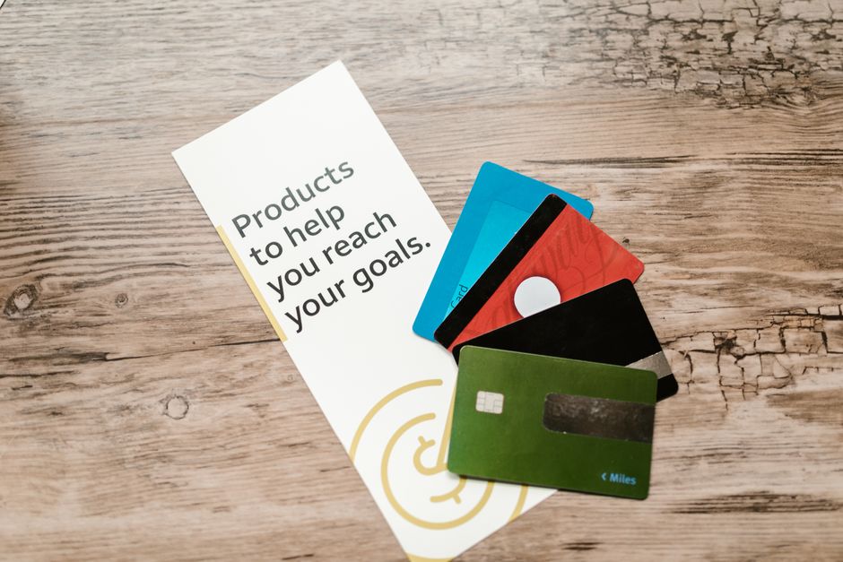 Several plastic credit cards fanned out on a wooden table surface