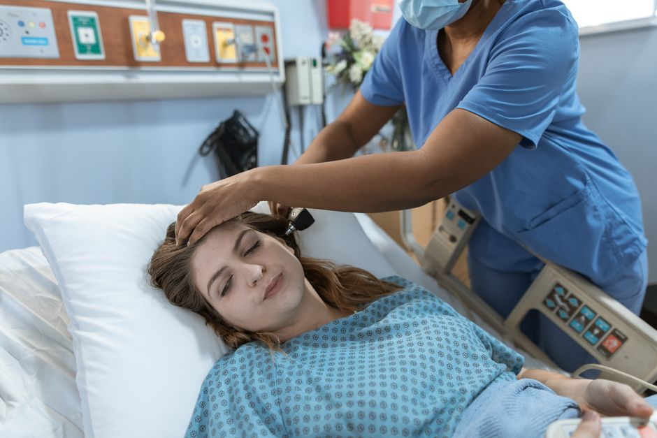 A nurse taking a seated patient's blood pressure in a clinical setting
