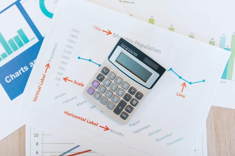 A stopwatch resting on a stack of printed documents on a desk