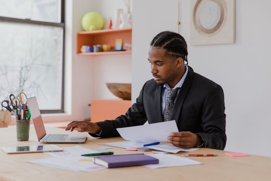 Small business owner reviewing invoices and mail at a shop counter