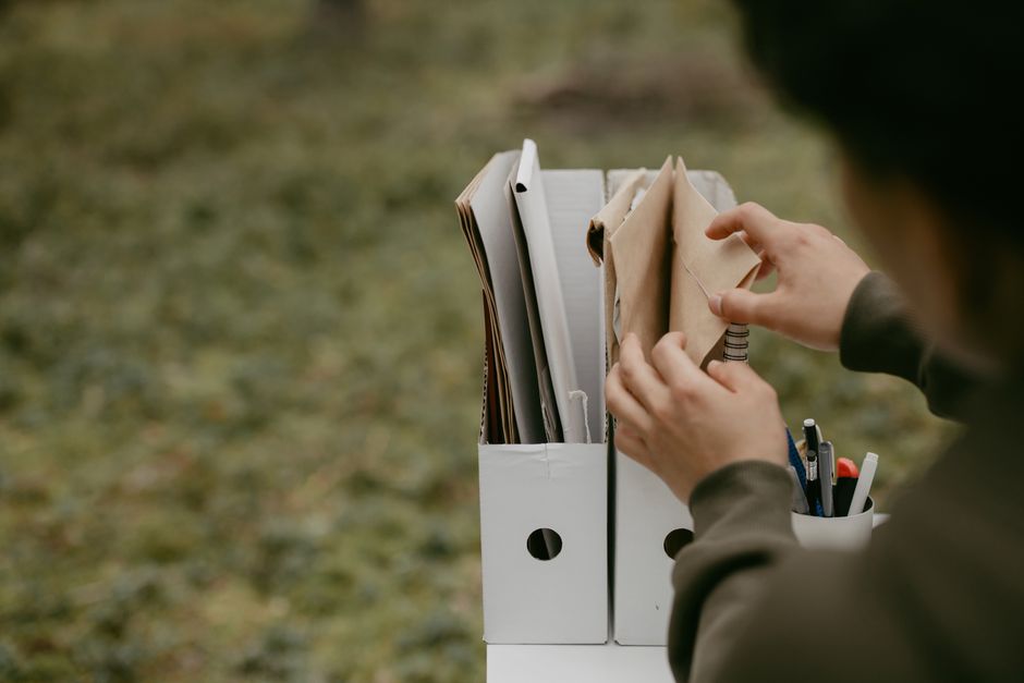 Person sorting receipts and documents into labeled folders before a meeting