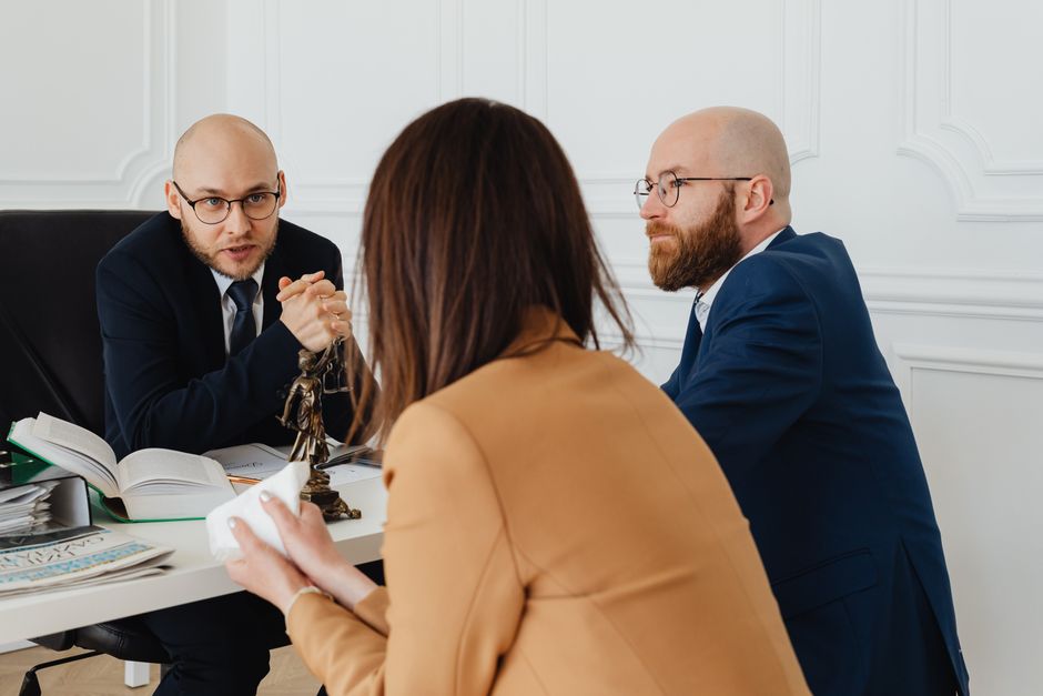Attorney across a desk discussing paperwork with a client in an office