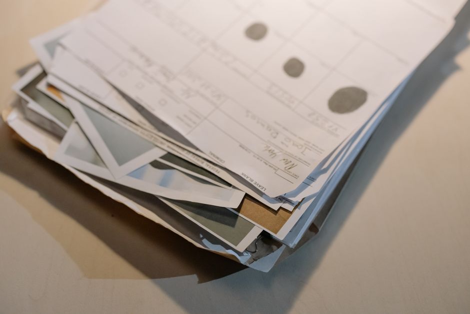 Thick stacks of filed documents and folders piled on an office desk