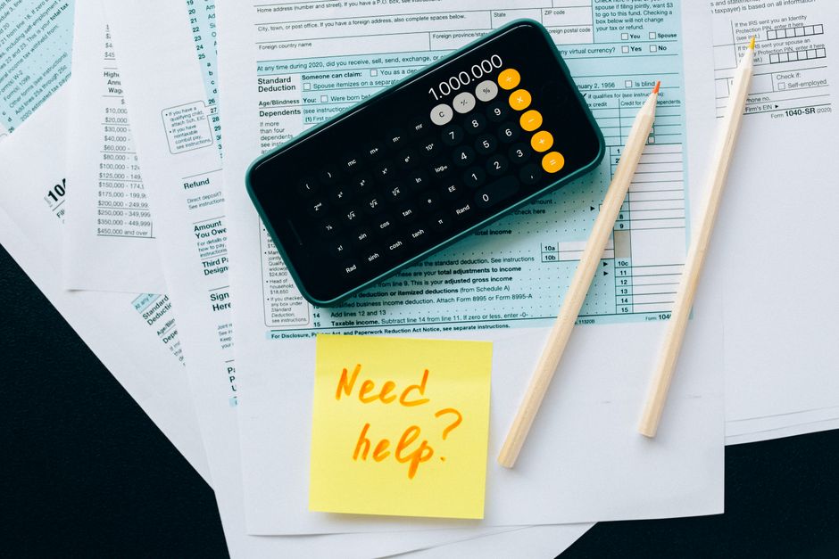 A federal tax form beside a calculator and pen on a wooden desk