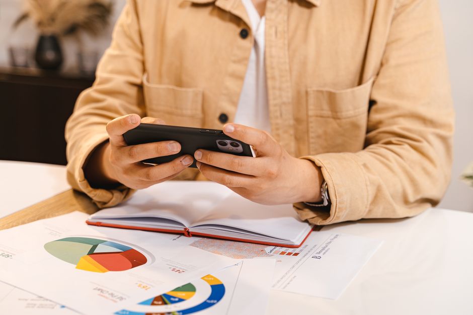 A person on a phone call while holding a page of paperwork
