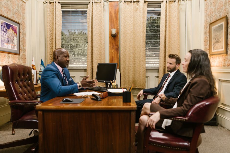 An attorney and a client reviewing paperwork together across a desk