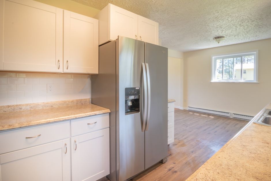 A newly installed stainless steel refrigerator standing in a bright home kitchen
