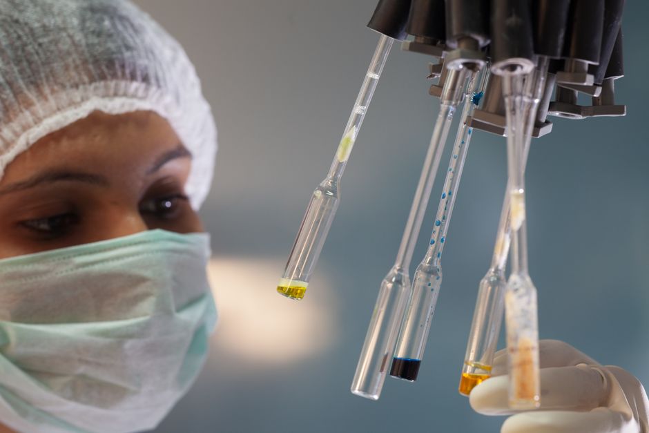 Laboratory technician in a lab coat testing food samples with instruments