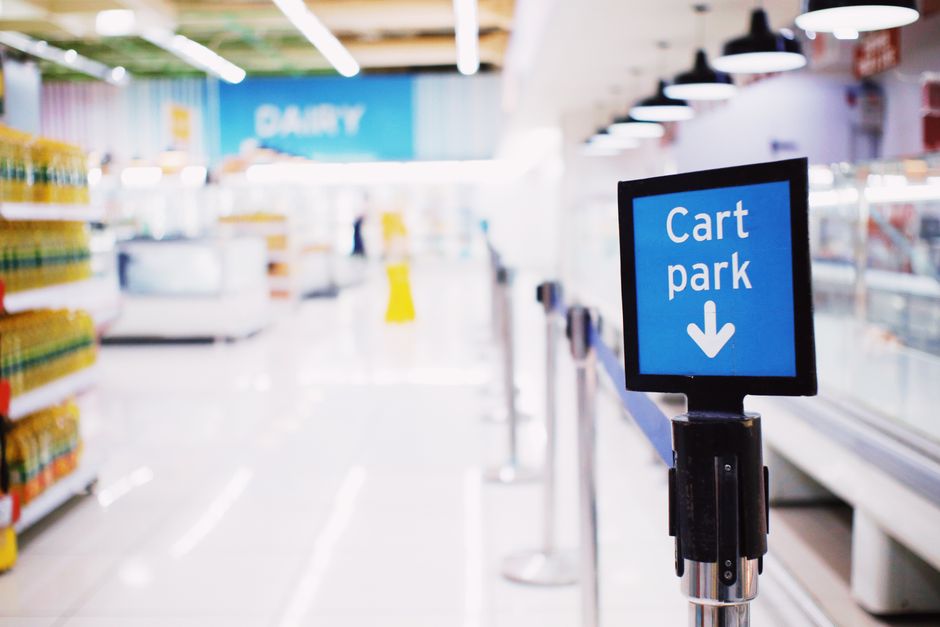 Shopper reaching for a dairy product in a refrigerated grocery store aisle