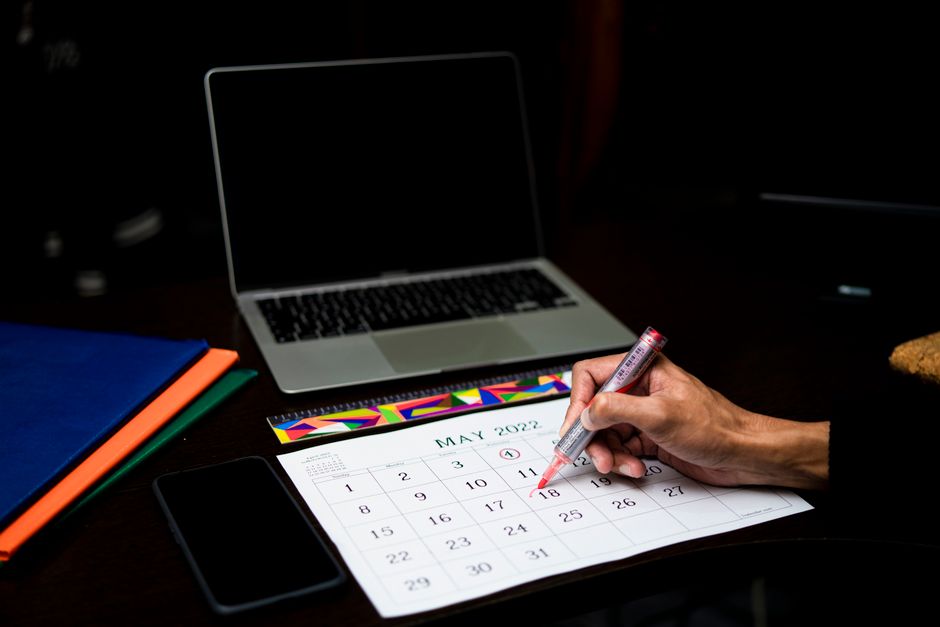 A wall calendar with dates circled and marked in pen