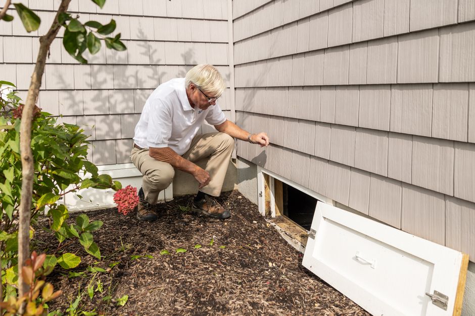Adjuster on a ladder photographing damaged shingles on a residential roof
