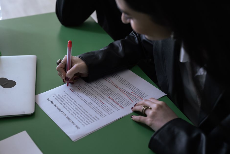 Hand marking up a printed document with a pen to make revisions