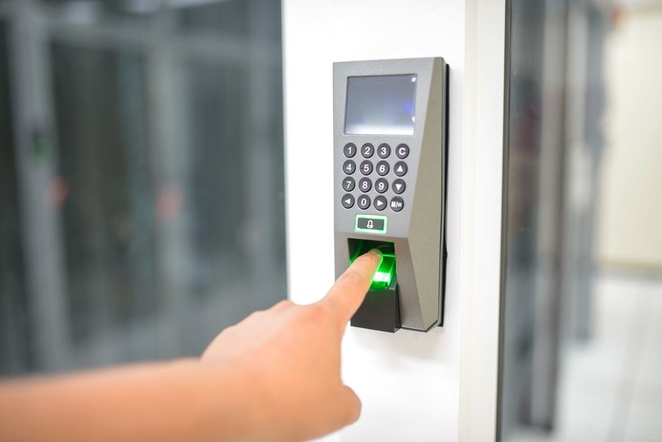 A person placing fingertips on an electronic fingerprint scanner at a service counter