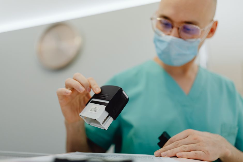 A hand pressing a rubber stamp onto an official paper document