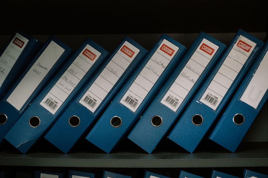 Stacked court case files and folders on a records office shelf