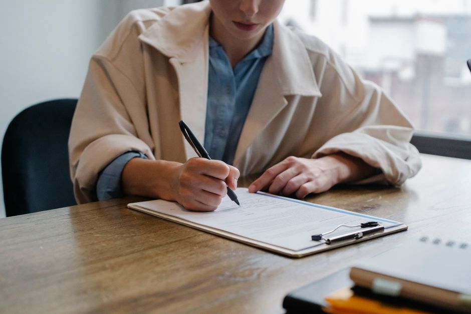 A person reviewing employment application forms and documents at a desk