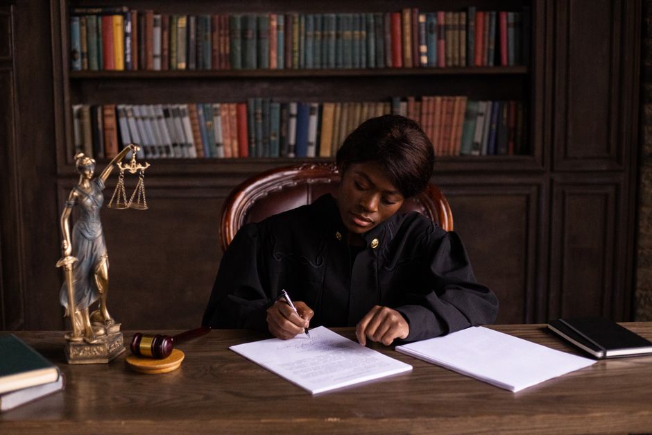 An open statute book beside a wooden gavel on a desk