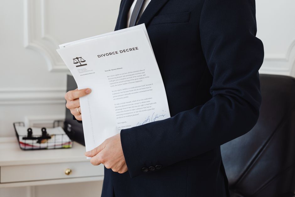 A person writing on a printed document with a pen beside a laptop